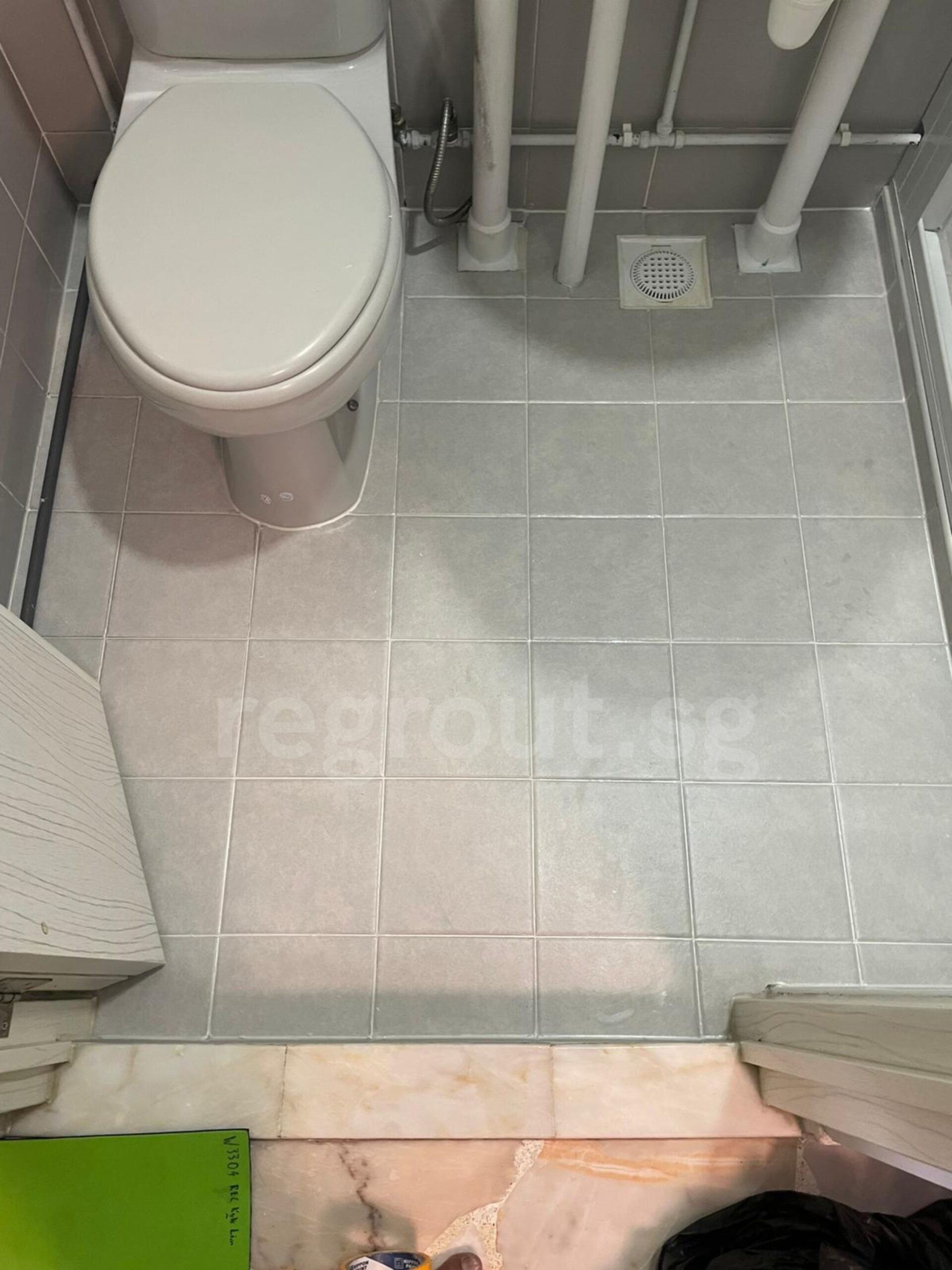 Polyurea grouting applied on bathroom floor tiles for clean white grout lines in Singapore home
